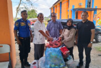 Kepala Diskominfo Aceh Besar, Muzakkir, SE yang didampingi Sekretaris Diskominfo, Khairul Huda, Skom, MM, menyerahkan bantuan pakaian layak pakai 