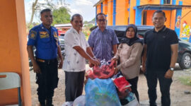 Kepala Diskominfo Aceh Besar, Muzakkir, SE yang didampingi Sekretaris Diskominfo, Khairul Huda, Skom, MM, menyerahkan bantuan pakaian layak pakai 
