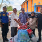 Kepala Diskominfo Aceh Besar, Muzakkir, SE yang didampingi Sekretaris Diskominfo, Khairul Huda, Skom, MM, menyerahkan bantuan pakaian layak pakai 